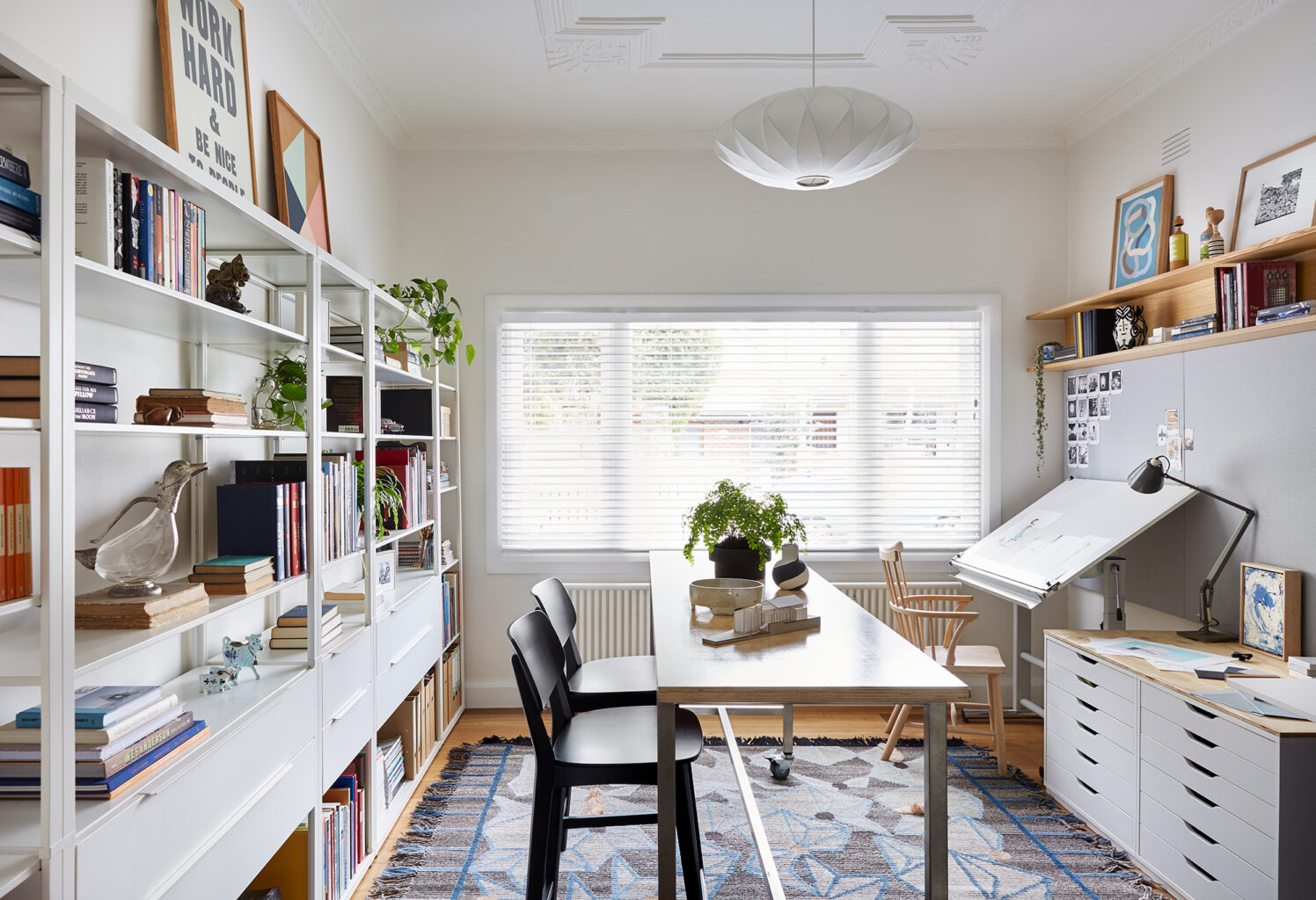 Maike Design creative workspace with textured rug, bookshelves and drawing board