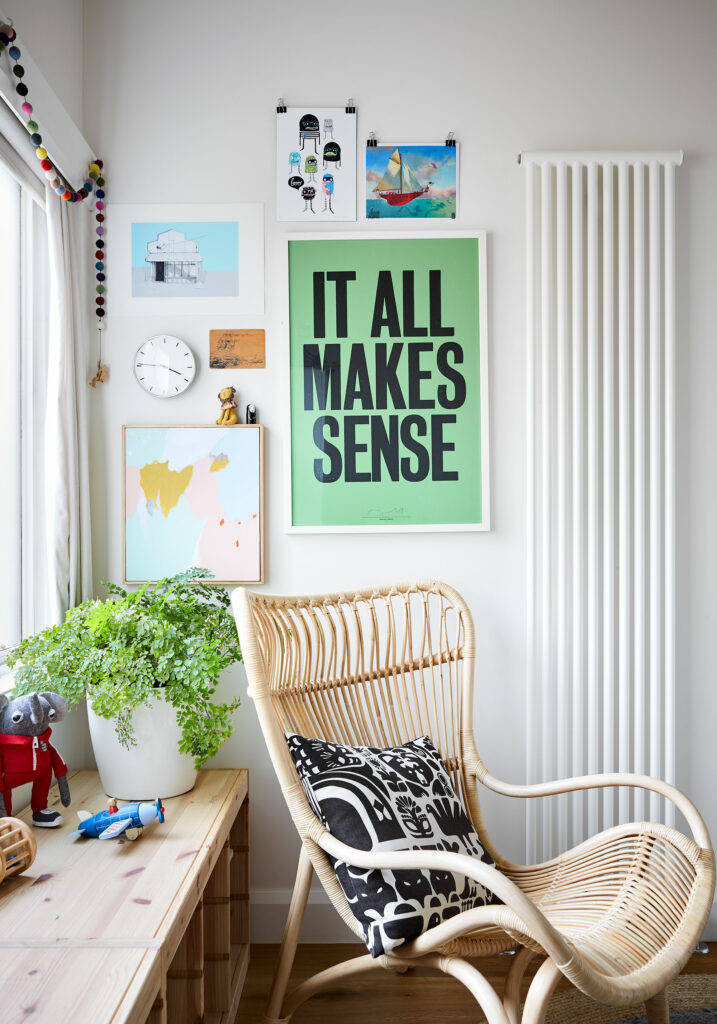 Maike Design nursery with artwork, wicker chair and plants