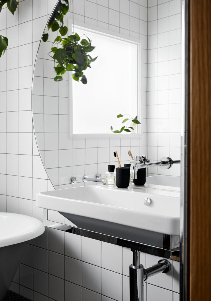 Maike Design bathroom with large round mirror and wall hung vanity