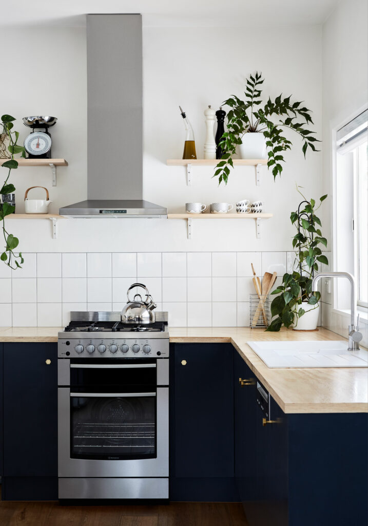 Maike Design navy blue kitchen with brass hardware and open kitchen shelving
