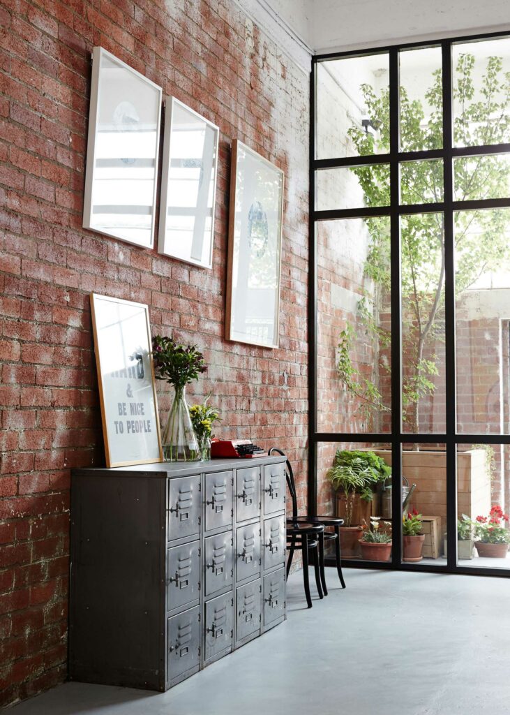 Maike Design Creative workspace, warehouse conversion. Redbrick wall, industrial lockers and indoor tree