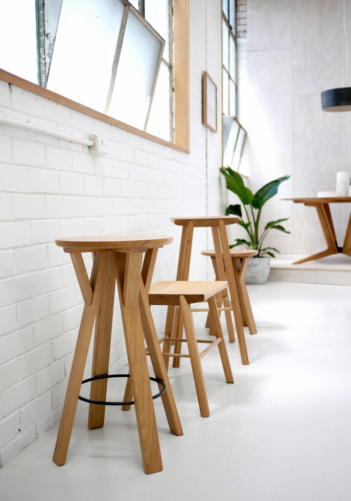 Maike-Design_TIDE-showroom-7 Maike Design furniture showroom with painted brick walls and industrial factory windows. Timber stools