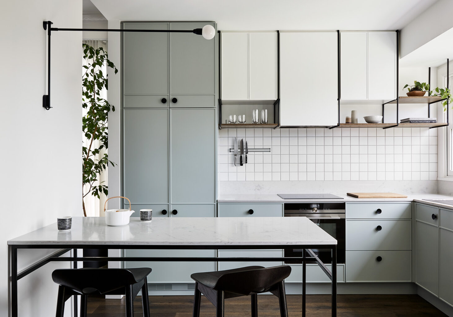 Maike Design light green kitchen. Custom cupboard design, black handles and marble benchtop.