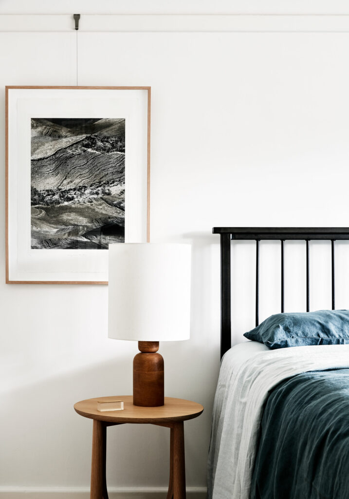 Maike Design Bedroom. Timber lamp and side table. Photographic artwork. Blue linen.