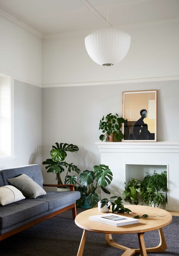 Maike Design renovated Californian Bungalow. Living room with indoor plants, fireplace and artwork