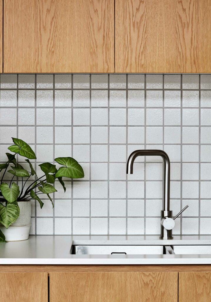 Maike Design kitchen. Timber joinery with stone tops. Textured tile splashback.