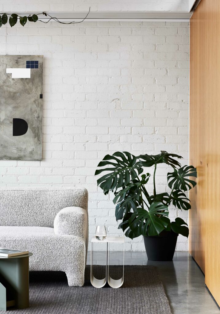 Maike Design lounge room. White painted bricks, indoor plants and timber joinery