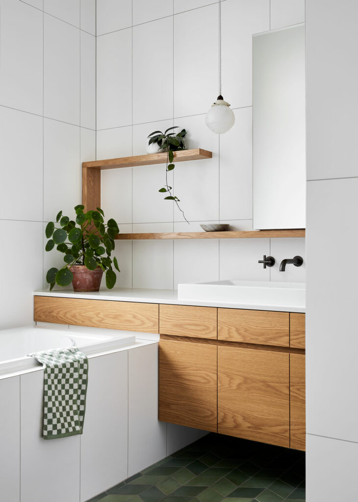Maike Design bathroom. White and green tiles. Antique pendant light, timber joinery and charcoal tapware