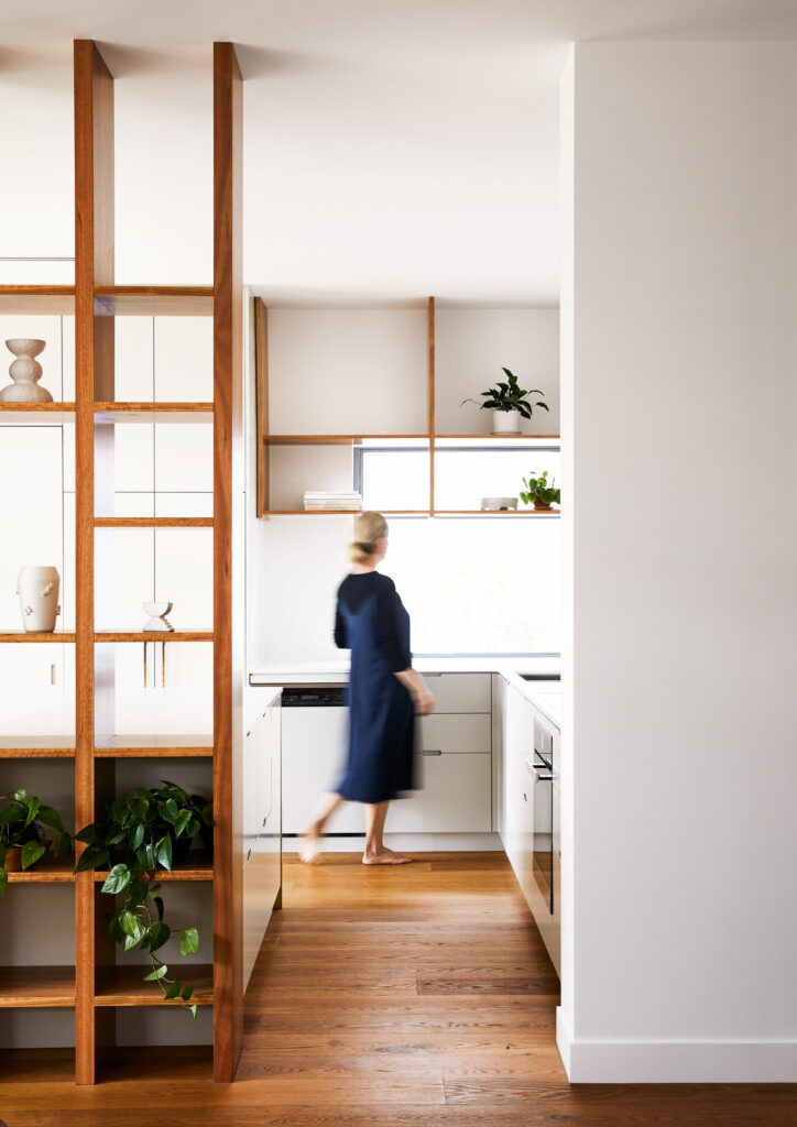 Maike Design kitchen. Open timber shelves, indoor plants, brass tapware, teracotta tiles, timber floors.