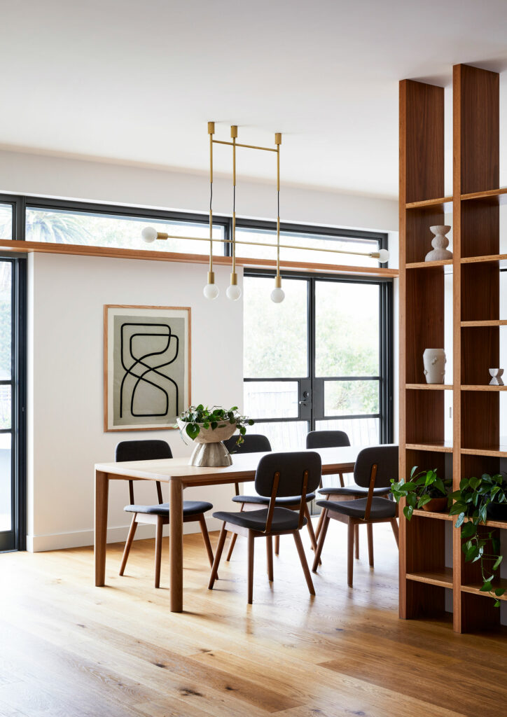 Maike Design dining room. Open timber shelves, brass pendant light. Minimal artwork. Indoor plants. Steel windows