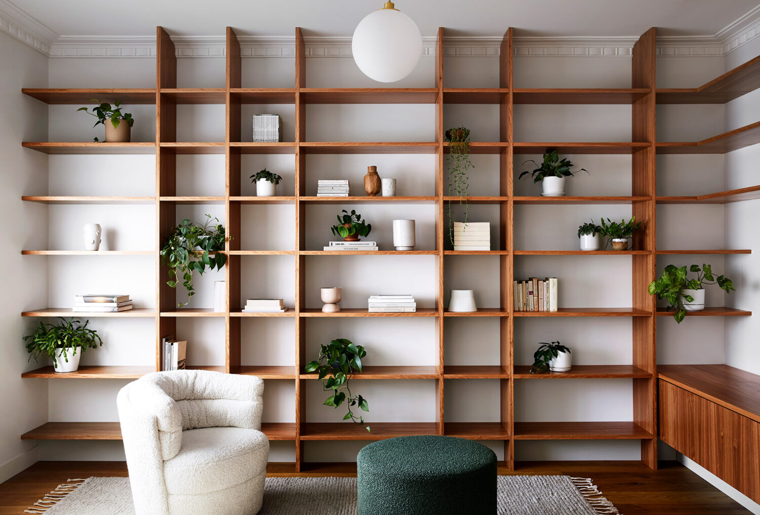 Maike-Design_Meow-House-7 Maike Design lounge room. Timber shelving, indoor plants. Boucle chair and ottoman.