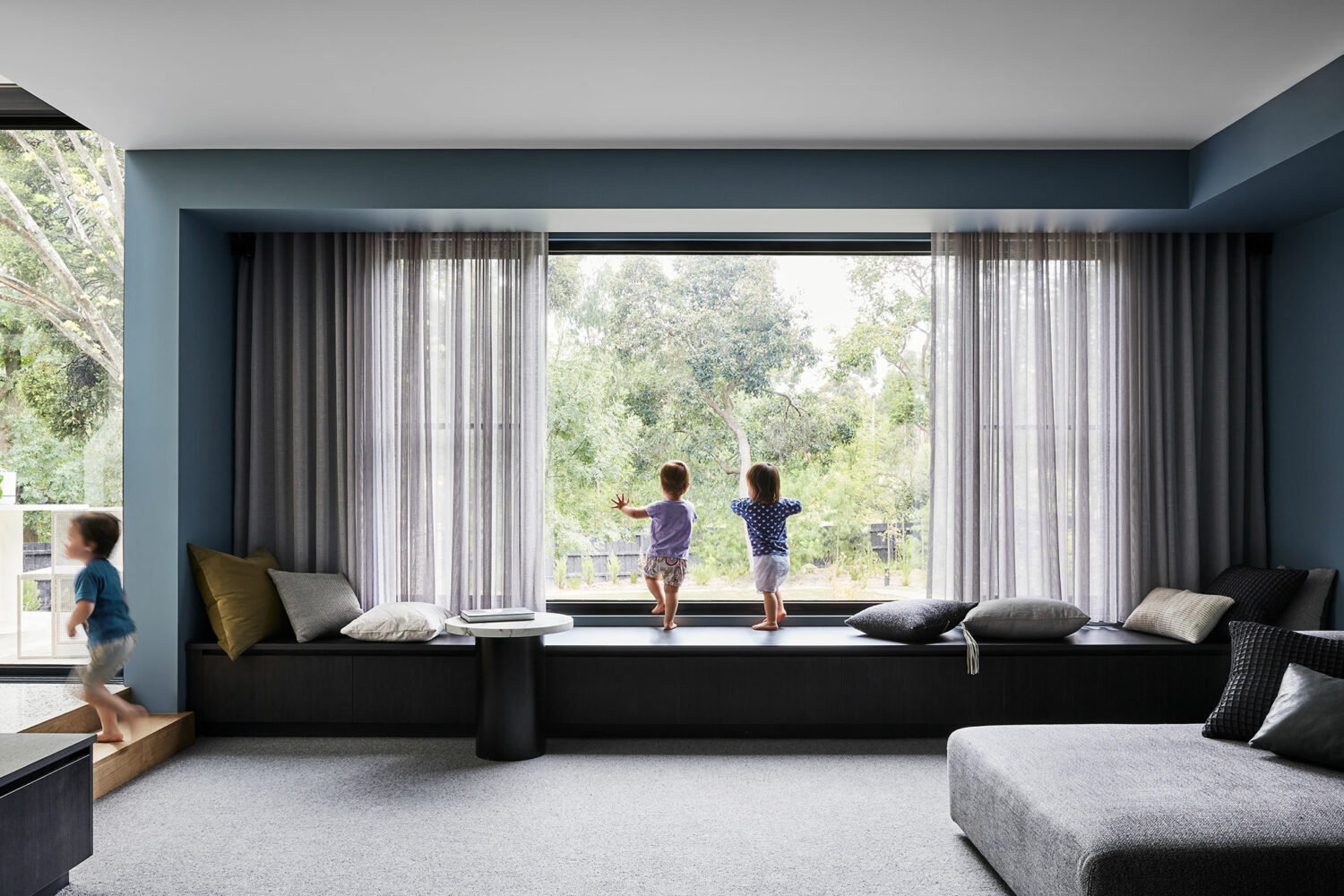 Maike-Design_Little-Big-House-23 Maike Design lounge room. Bench steat and sheer curtains. Blue painted walls