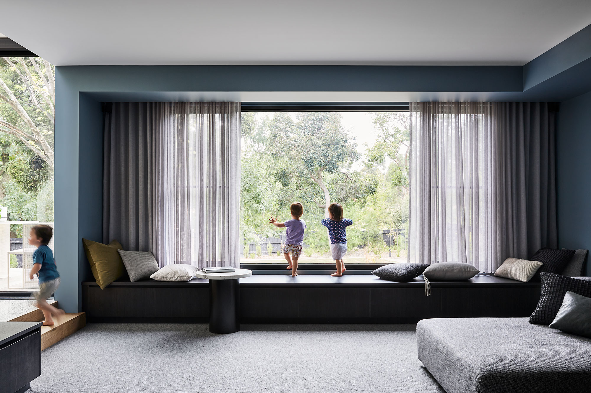 Maike-Design_Little-Big-House-23 Maike Design lounge room. Bench steat and sheer curtains. Blue painted walls